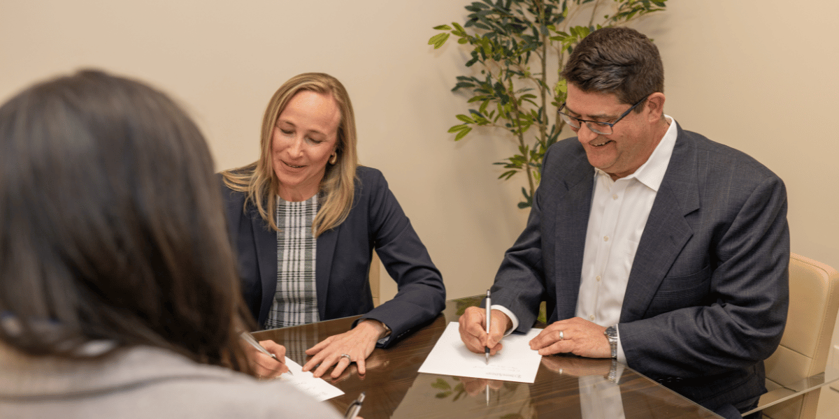 2 attorneys sitting at a conference table advising a client