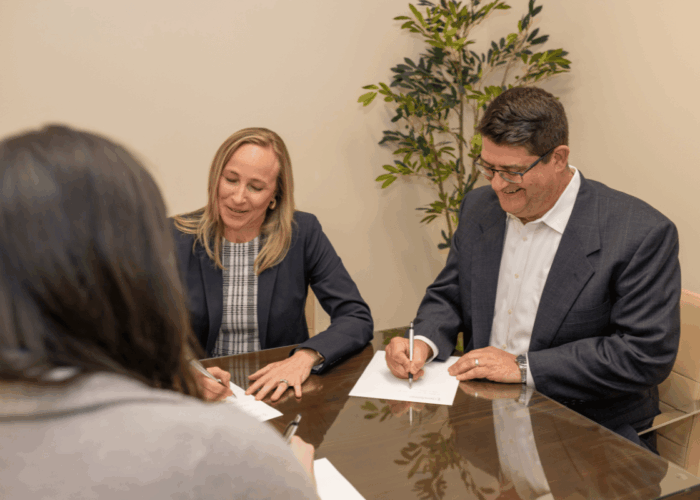2 attorneys sitting at a conference table advising a client