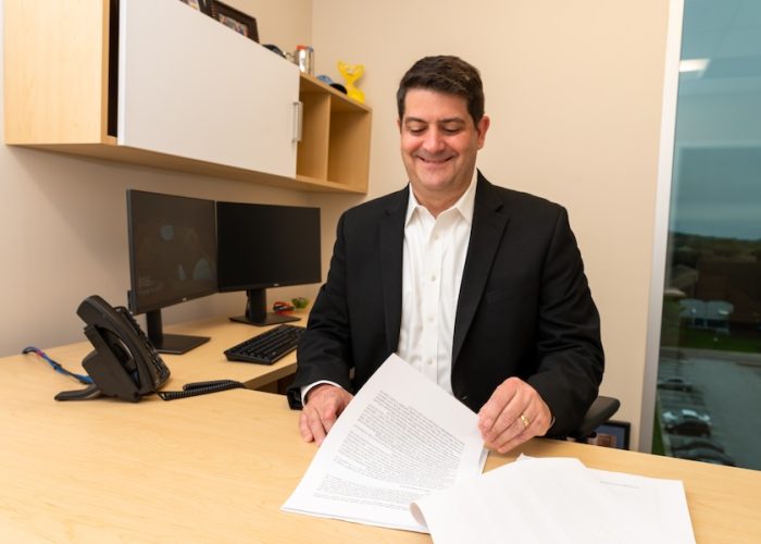 ney Thomas Sessa at his desk reviewing paperwork.