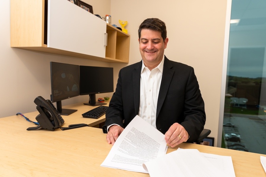 ney Thomas Sessa at his desk reviewing paperwork.